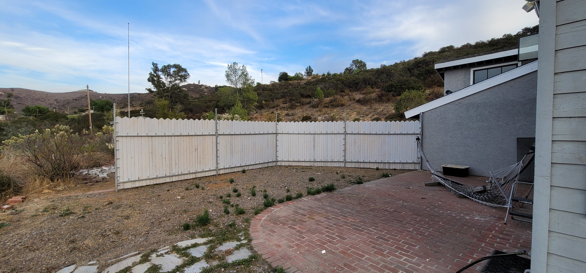 Privacy fence separating patio from guest house and driveway - 5513 Riggs Rd