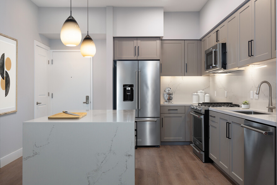 Signature Collection kitchen with upgraded stainless steel appliances, grey cabinetry, white marble countertops and backsplash, and hard surface flooring - Avalon Walnut Creek