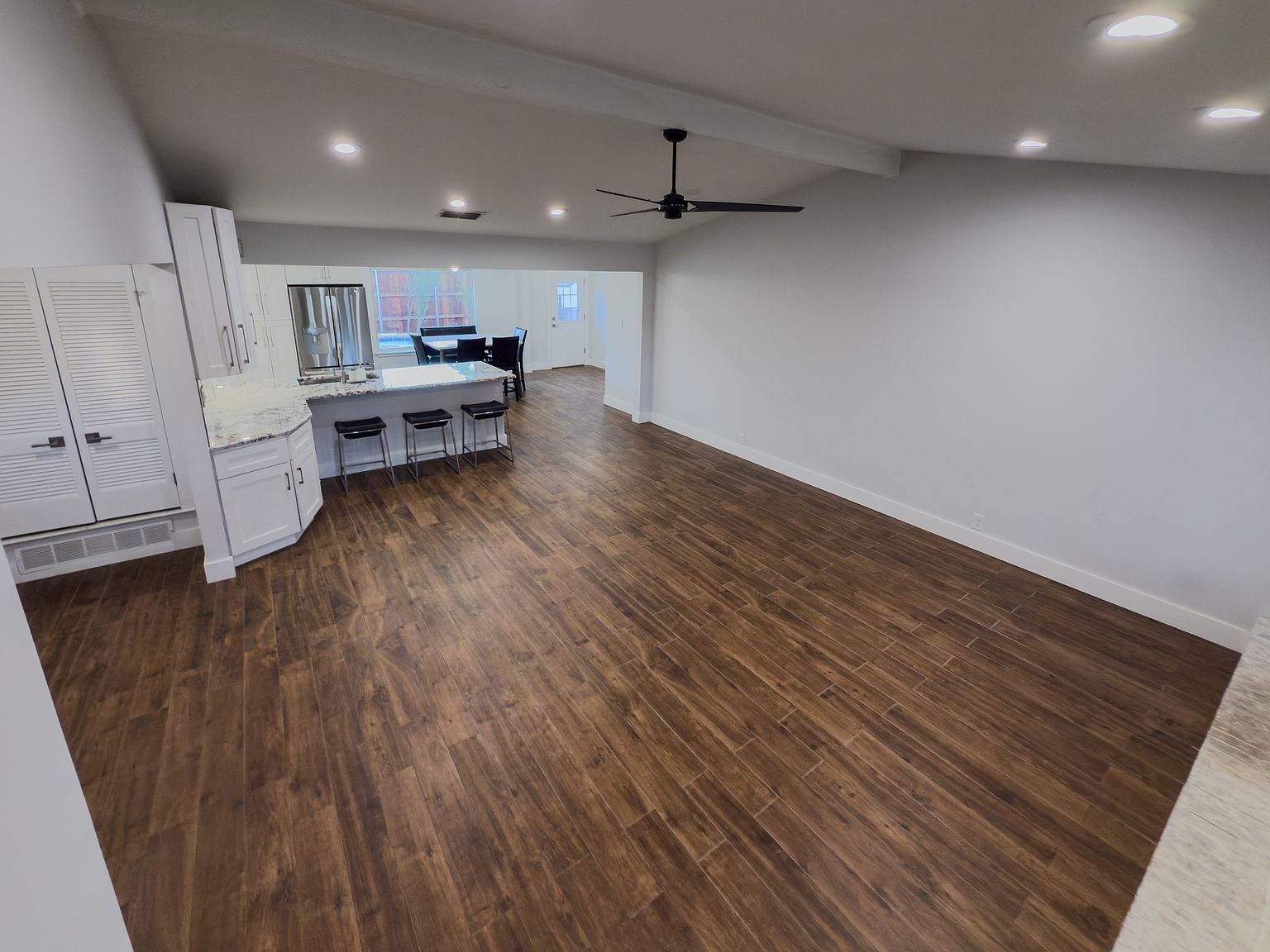 Open-concept living room with hardwood floors and modern ceiling fan - 2006 Candle Ct