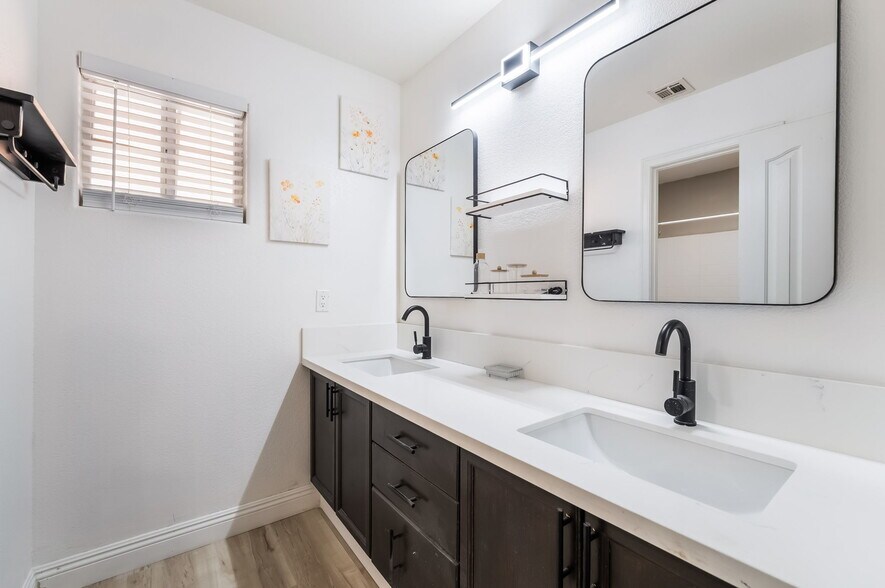 Bathroom featuring light wood finished floors and double vanity - 1179 Antoinette St