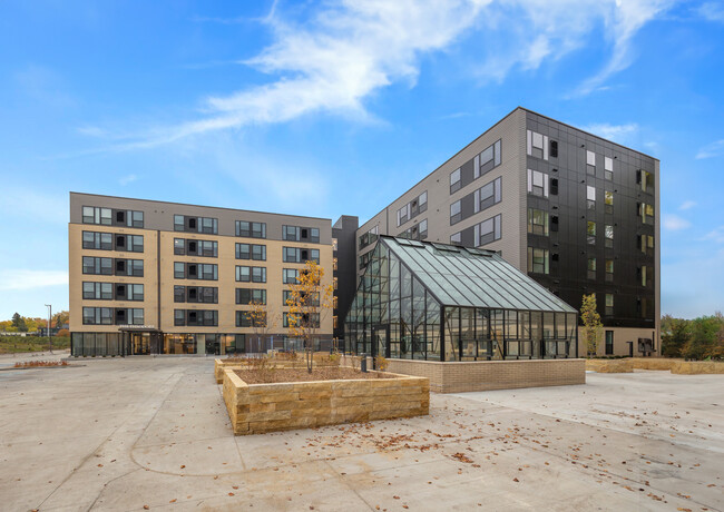 Exterior w/ Greenhouse - The Theodore Apartments 55+