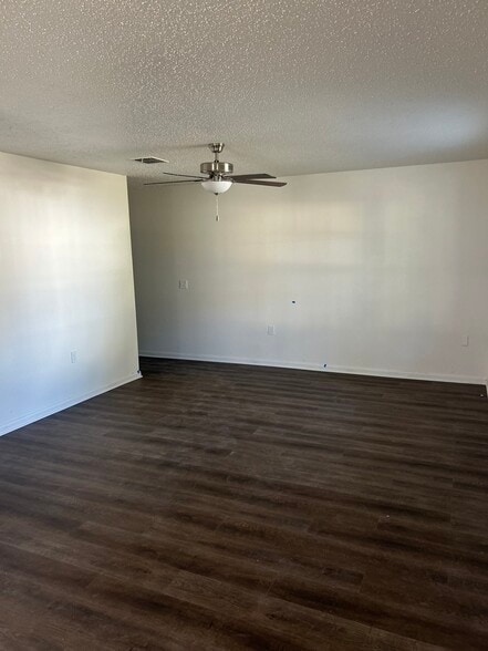 Spacious living room with modern ceiling fan and waterproof flooring - 4720 Burma Rd
