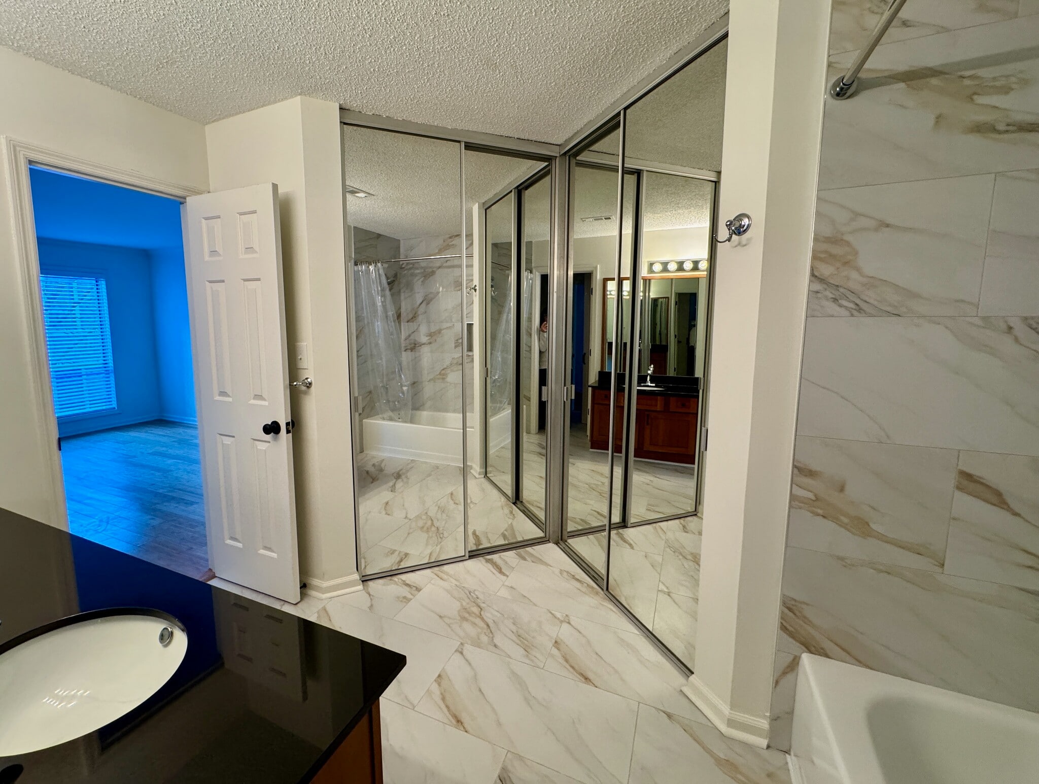 view of walk-in closet with mirrored doors, with bedroom seen at left - 209 14th St. NE #119