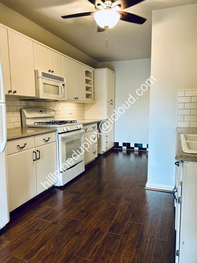 Spacious kitchen quartz counter tops with gas stove, built-in microwave, fridge, dishwasher, garbage - 629 Hillpine Dr NE
