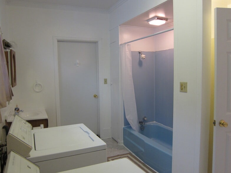 Full bathroom features a laundry room as well with washer/dryer included. Doors connect to kitchen and bedroom #2. - 1445 South Center Street