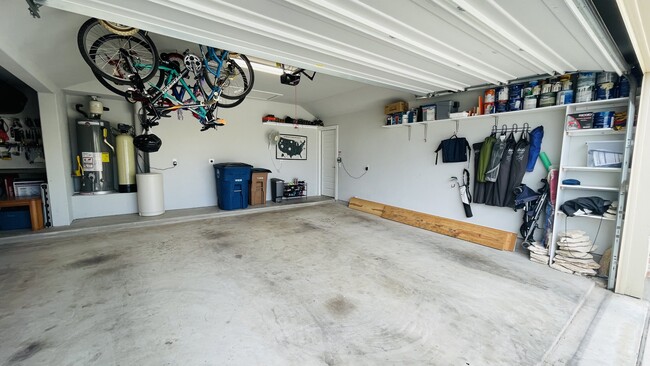 2.5 car garage with shelving/storage, bike hooks hung to alert car stop, wall hooks, attic, EV plug - 7108 Garnet Mill Ln