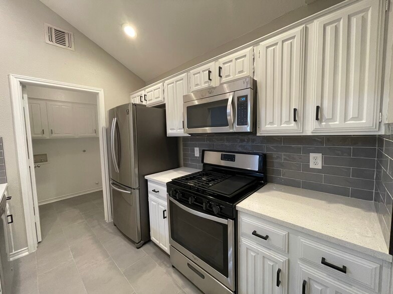 Quartz countertops in the kitchen along with all new stainless steel appliances, featuring a gas oven range, vented microwave, French door refrigerator with built ice maker, dishwasher and garbage disposal. you will love the vaulted ceiling and tons of natural light from the skylights! - 812 Via Madonna