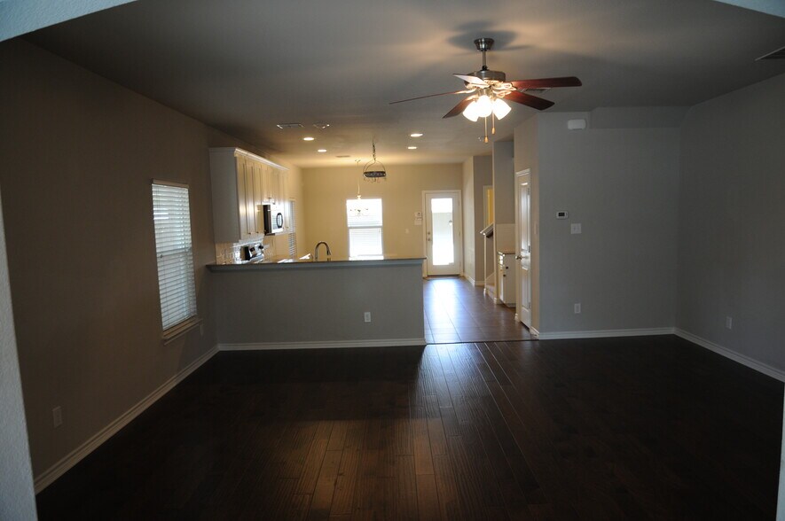 Open concept living area with hardwoods & ceiling fan - 3426 W 4th St