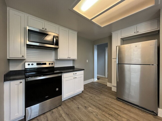 Building Photo - Three-Bedroom Home with Updated Kitchen & Vaulted Ceilings, large open basement, Hardwood floors