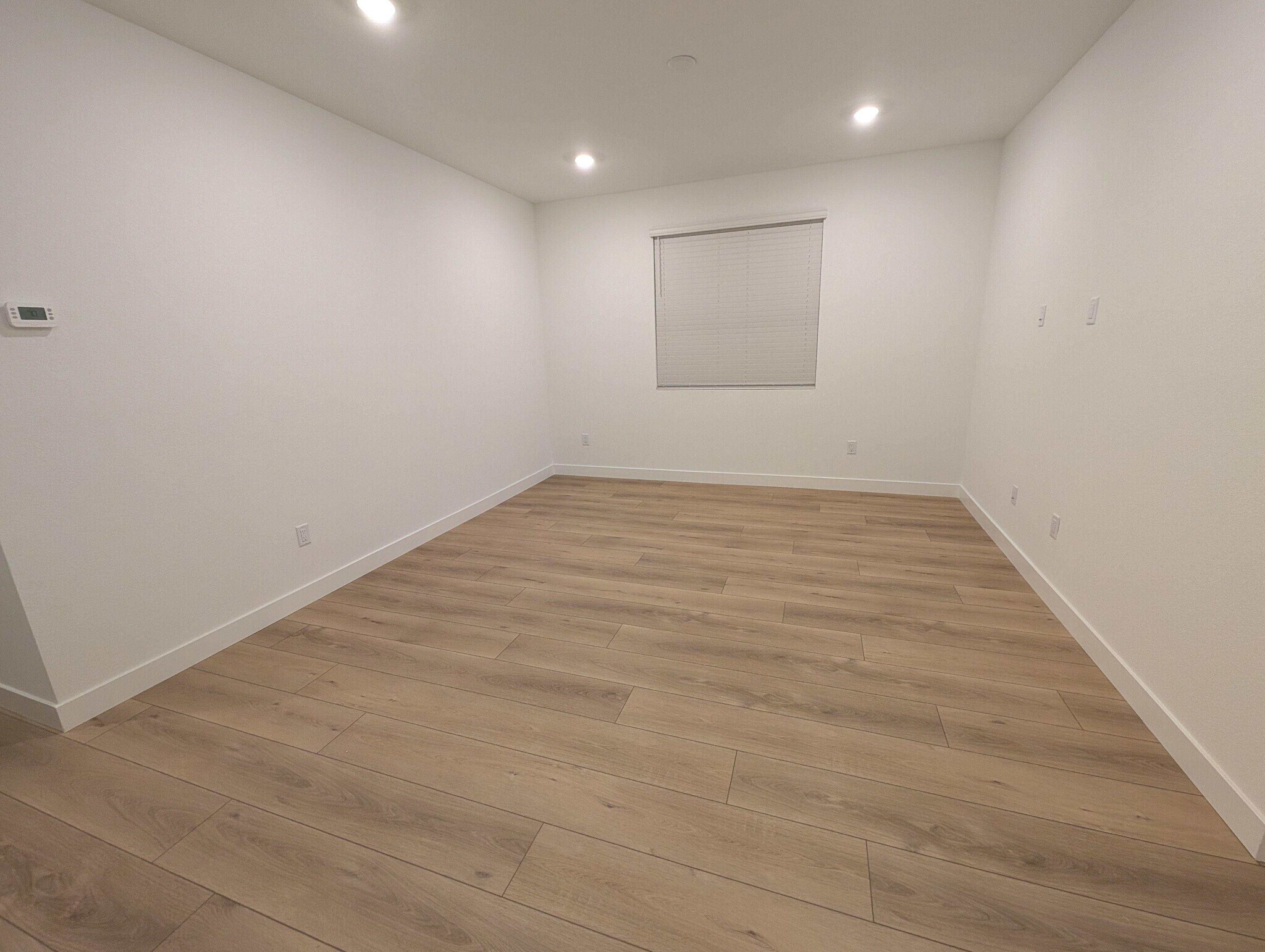 Large 18' x 13' living room with modern plank flooring and large window - 628 S Cecita Wy