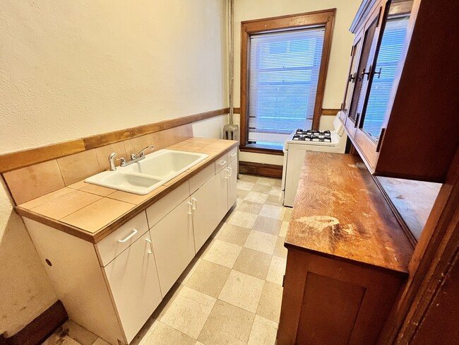 Experience the warmth of this inviting kitchen, perfect for culinary creations. - Cross Apartments