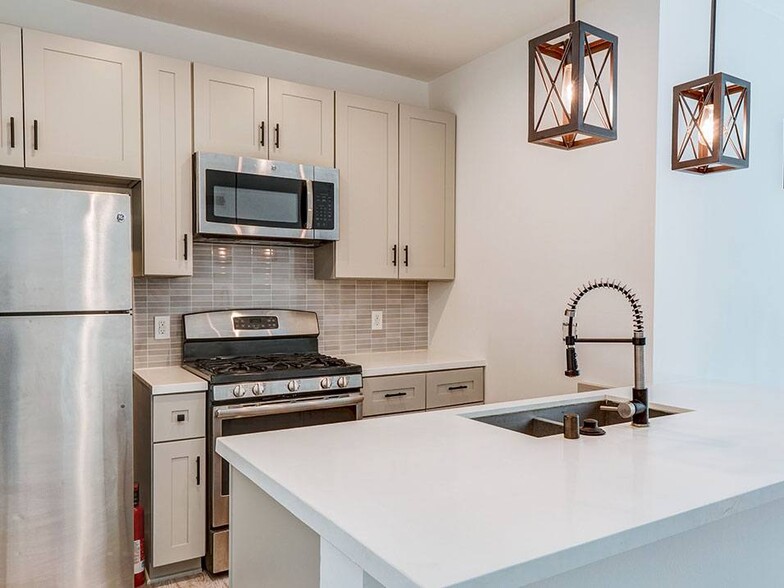 Kitchen with new modern styled faucet, stainless steel appliances, and refrigerator. - Bonita Terrace