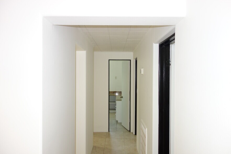 Hallway, Primary bedroom on right, bathroom ahead, kitchen to the left - 1745 S Birmingham Ave