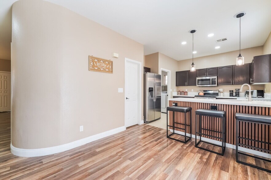 Kitchen featuring appliances with stainless steel finishes, decorative light fixtures, light wood-st - 1179 Antoinette St