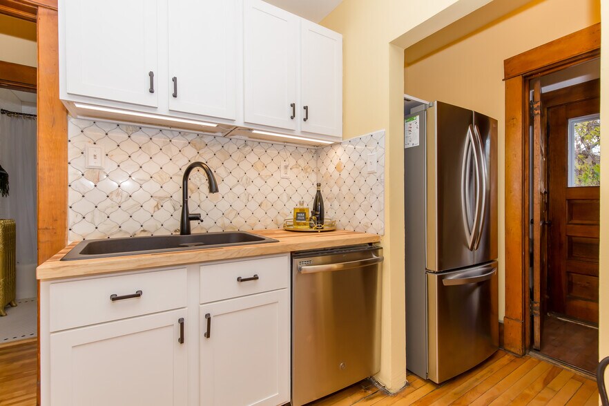 Kitchen features decorative ceramic tile backsplash and cedar butcher block countertop - 715 5th St SE
