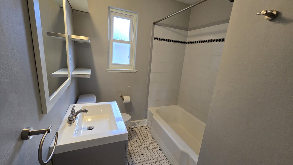 Full bathroom is currently being updated! New 2-tone tile surround, black fixtures and mirror. - 5701 E 28th Ave