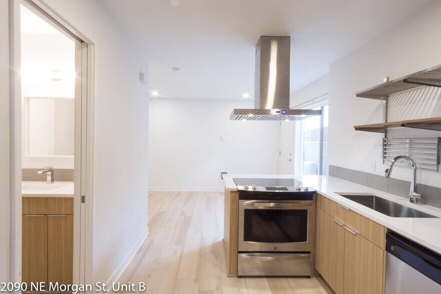 Kitchen features full size range, chimney hood, quartz counters, and under-mount sink. - 2090 NE Morgan St