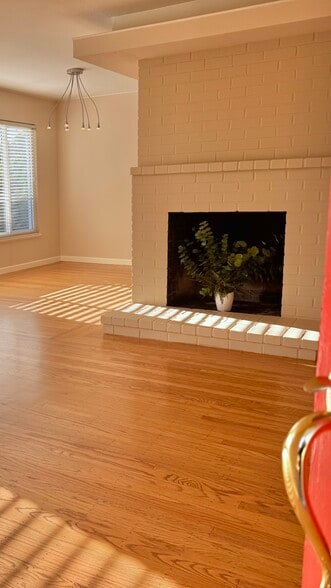 Step inside to a light-filled living area featuring warm, newly refinished hardwood floors, fresh pa - 2403 Mira Vista Dr