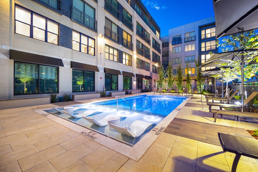 Resort-style pool with Sunbrellas and in-pool chaises - Hanover Evans Station