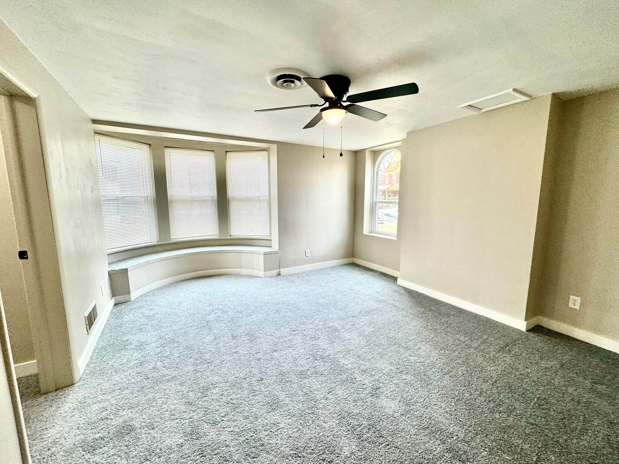 Large bedroom with new paint, carpet and ceiling fan. - 7100 Thomas Blvd