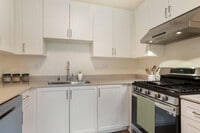 Renovated Package I kitchen with stainless steel appliances, white cabinetry, beige granite countertops, and hard surface flooring - eaves Mission Ridge