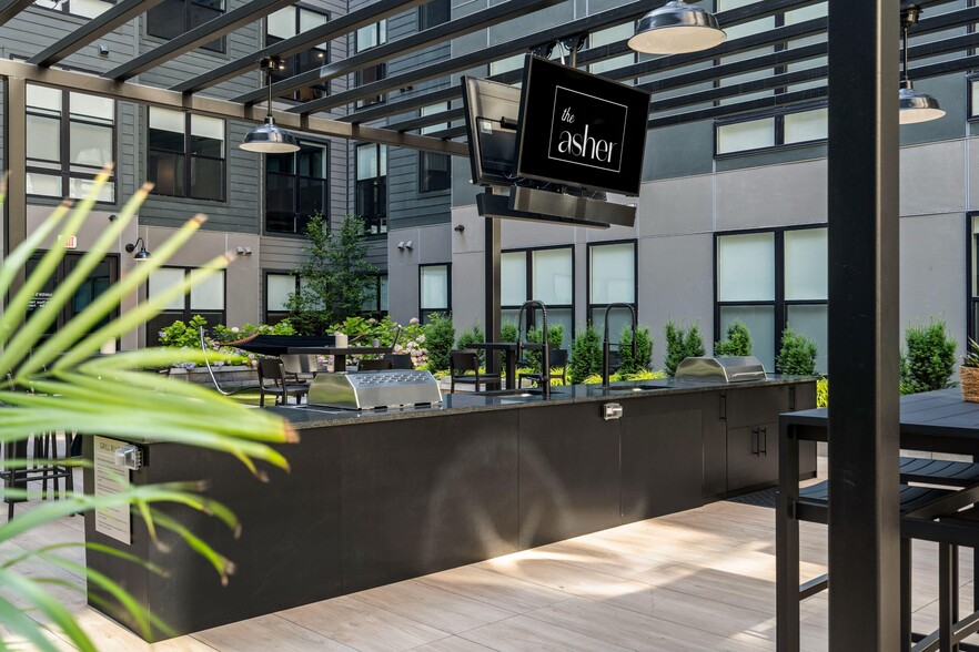 Central courtyard featuring lounge seating, bar area, outdoor tv&#39;s, and grills - The Asher