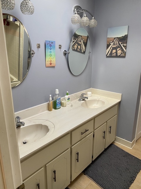 Primary bathroom with double vanity and tub with shower - 810 E 23rd Ave