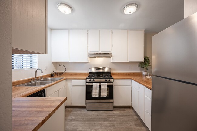 Kitchen with white cabinets and stainless steel appliances - Oak Park Apartments