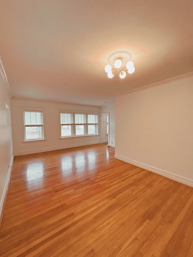 The spacious living and dining space features a bank of windows with a view of Tower Grove Park - 2705 S Kingshighway Blvd