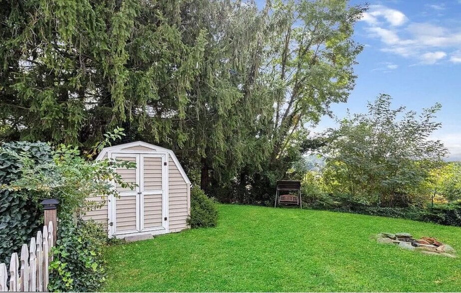 Fenced in Backyard with deck and fire-pit. - 324 Woodland View Dr