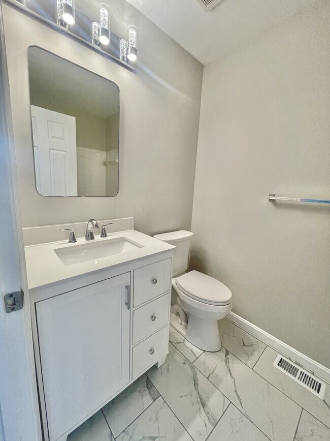 Renovated primary bathroom with ceramic tile, new vanities, toilets, lights, and mirro - 12430 Horseshoe Bend Cir