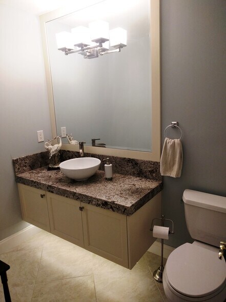 Gorgeous powder room with floating vanity and custom lighting - 2662 NW 42nd St