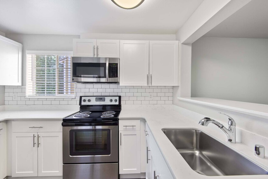 Prepare your favorite meals in a sleek, modern kitchen featuring stainless steel appliances and clean, contemporary finishes. - Windsor Juanita Bay