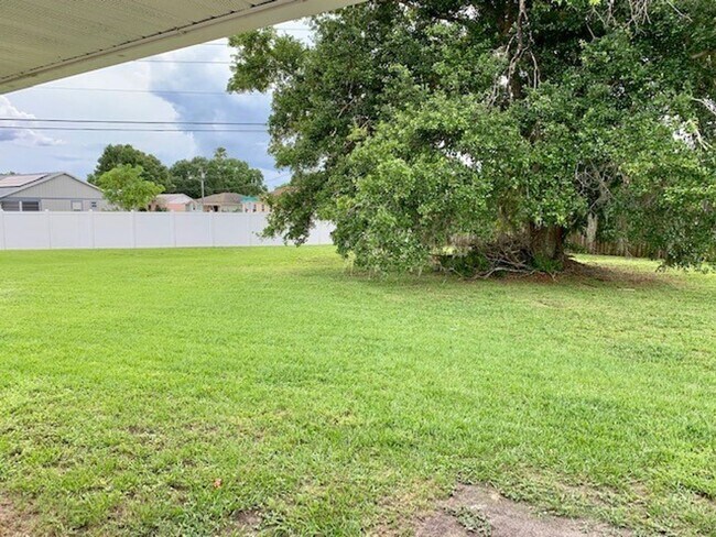 Building Photo - Available NOW! NEW FLOORS AND PAINT! Lovely 3/2 in Poinciana! HUGE fenced yard and NO CARPET!