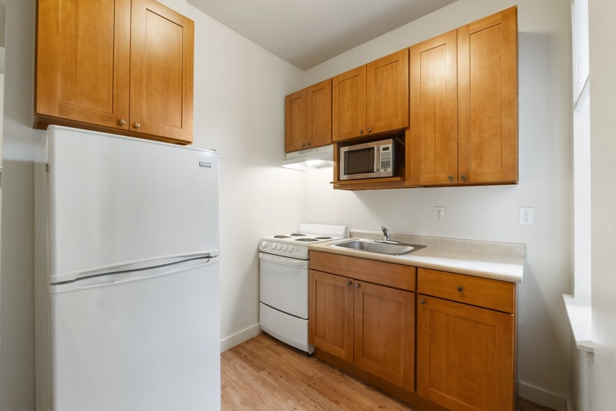 Studio kitchen with refrigerator, microwave, oven & range - Milwaukee Apartments