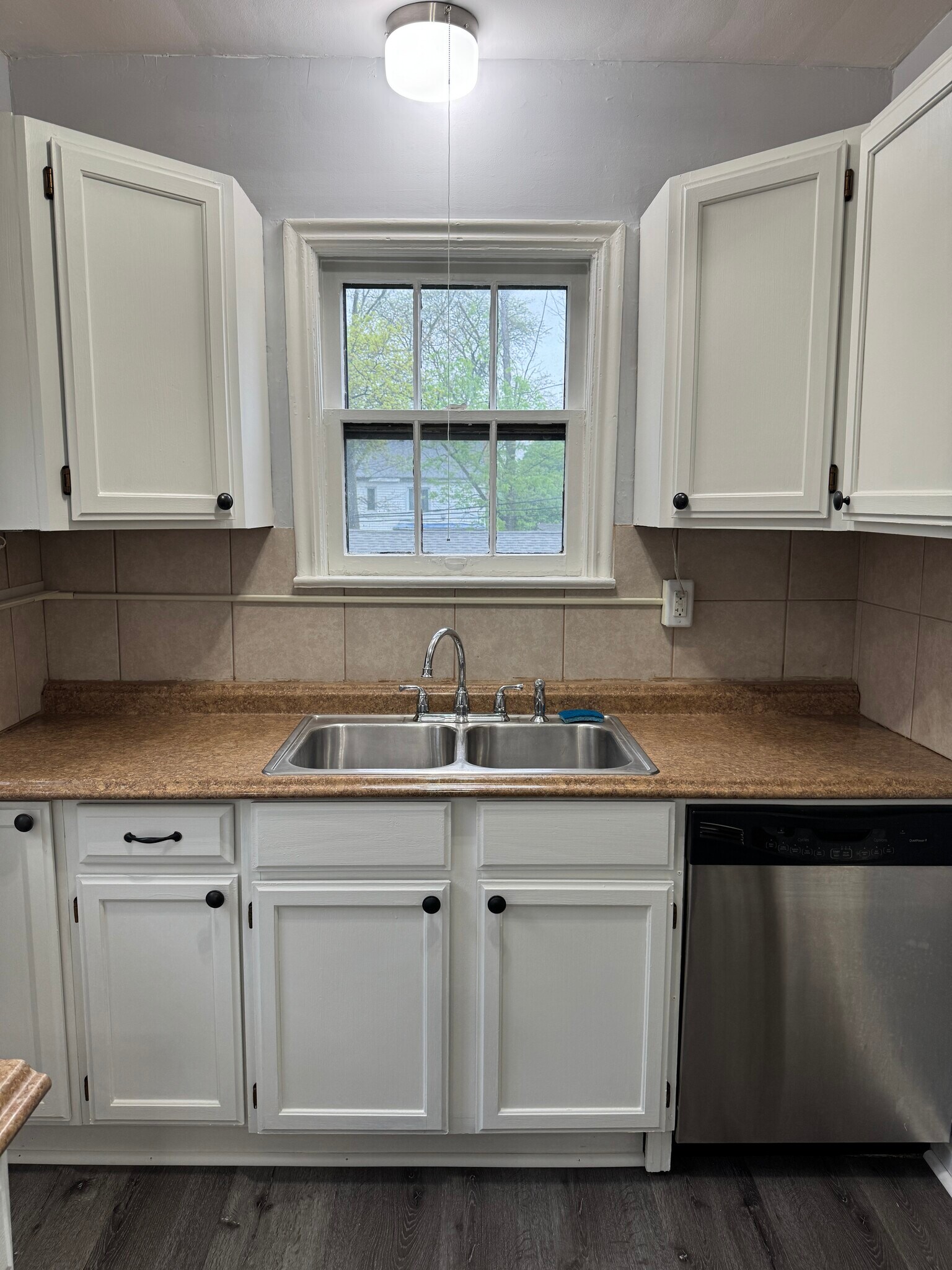 Kitchen sink area with window, storage, and clean neutral finishes. - 3682 Glencairn Road