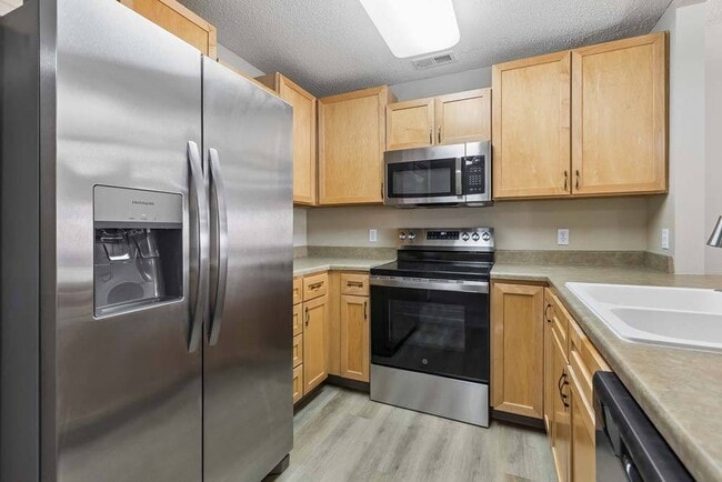 Thoughtfully designed with stainless steel appliances and warm cabinetry, this kitchen makes every meal feel inviting. - Southwind Villas