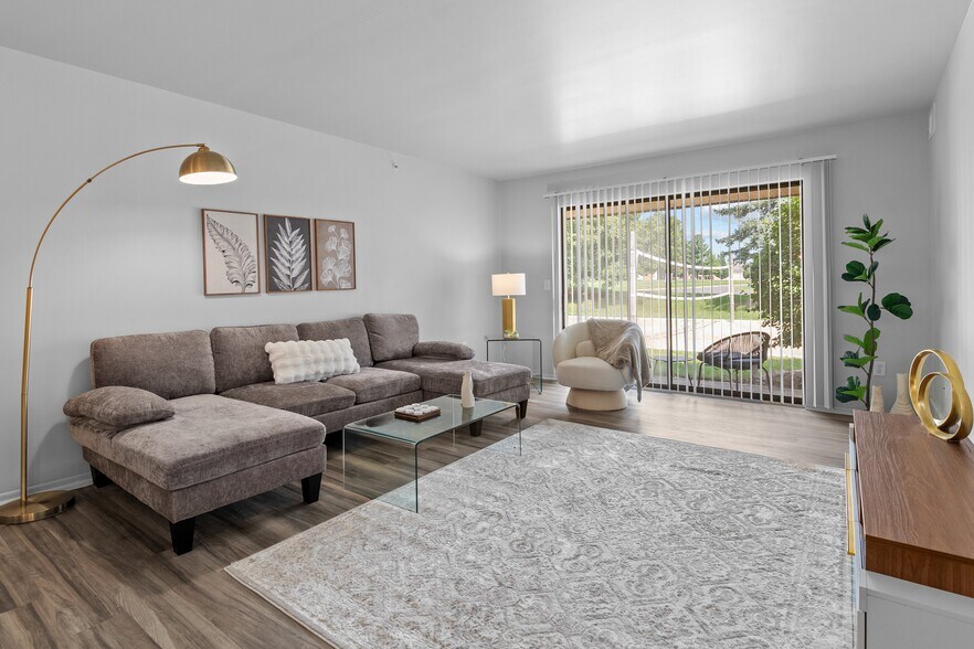 Living room with patio at Dover Hills Apartments in Kalamazoo - Dover Hills Apartments