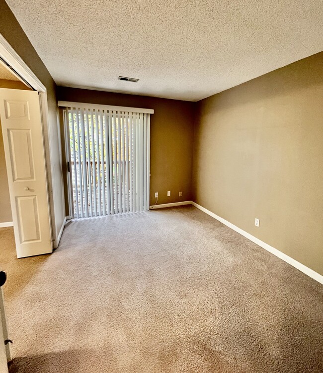 Second bedroom separated with bi-fold doors from master bedroom. Sliding doors lead to back deck - 1458 High School Dr