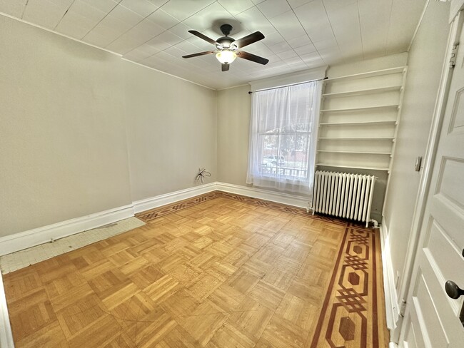 Elegant bedroom featuring classic wood flooring and abundant natural light. - 1458 N Gaylord St