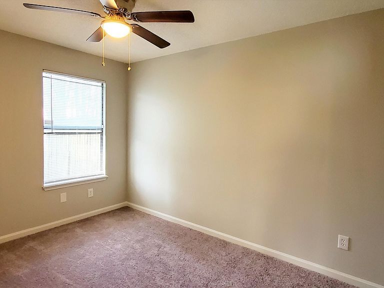 3rd bedroom with new paint, flooring, ceiling fan, closet, and view of private backyard. - 1300 Bay Hill Blvd.