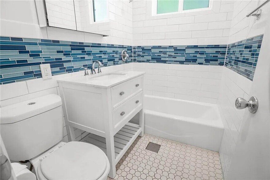 Updated bathroom with white shaker cabinetry, subway tile, glass inlay and more - 1500 Voorhees Ave