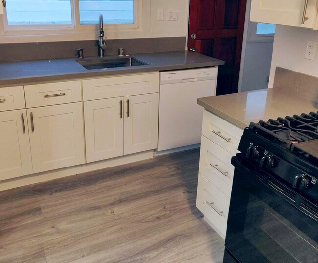 Dishwasher next to sink, and to the right the black stove with its nonstick griddle - 1828 S Curson Ave