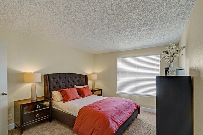 A bedroom with a wide window overlooking the property - Acacia Park