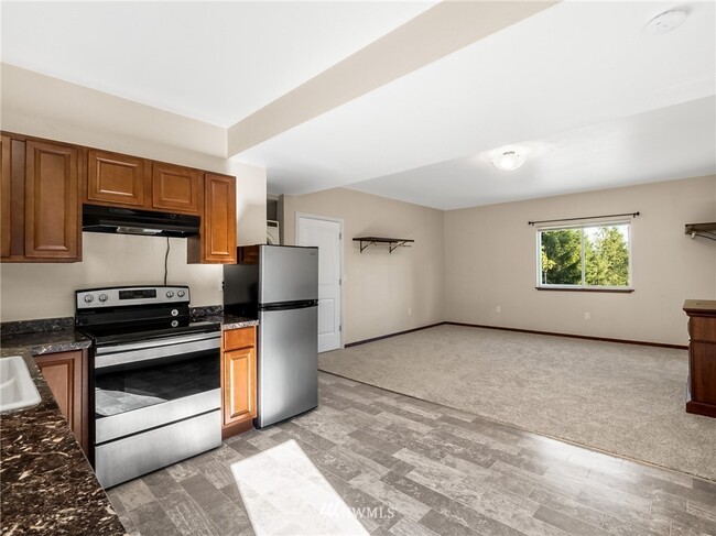 Kitchen features a stove and refrigerator - 10306 41st Trl SE