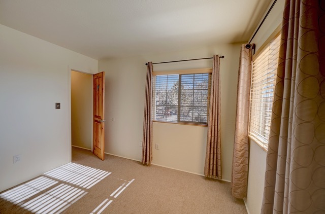 Unit 1011--Bedroom 1 with corner views of mountains and walk in closet - 2210 Miguel Chavez Rd