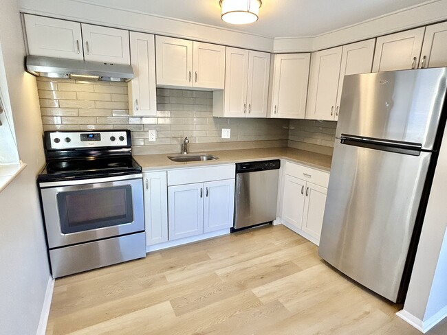 Experience modern culinary excellence in this sleek kitchen setup. - Oak Street Apartments
