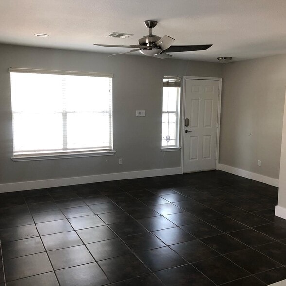 Living area with recessed lighting, updated fixtures, oversize baseboard, tile flooring - 615 Big Spring Dr