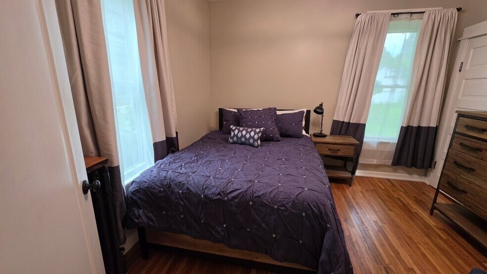 Comfortable main-level bedroom with hardwood floors and backyard views. - 1901 -2301 Fillmore Street NE Minneapolis, MN 55418