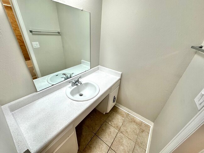 Experience the elegance of a bright bathroom with a contemporary vanity and spacious mirror. - Country Club
